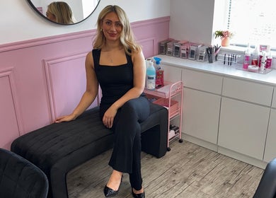 A stylist at LMA Beauty21 in Gloucester, England, GB in a modern, pink-accented salon space.