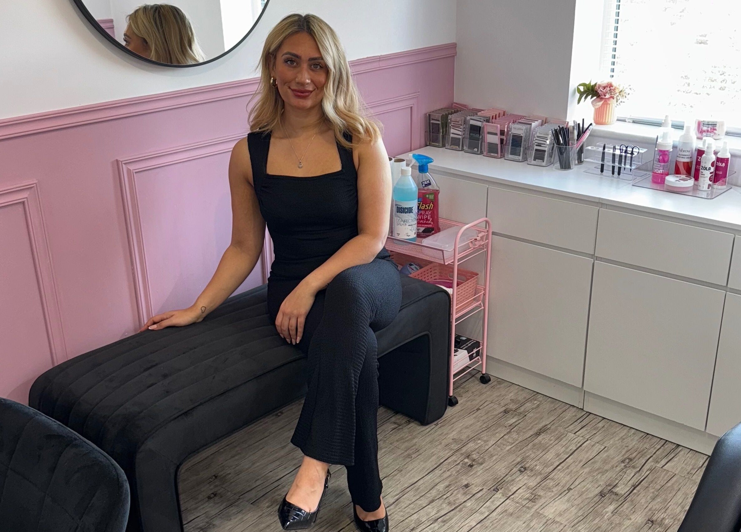 A stylist at LMA Beauty21 in Gloucester, England, GB in a modern, pink-accented salon space.