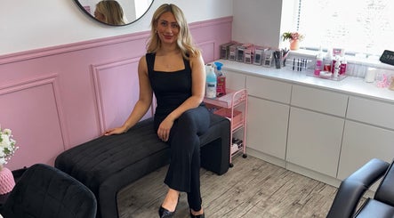 A stylist at LMA Beauty21 in Gloucester, England, GB in a modern, pink-accented salon space.