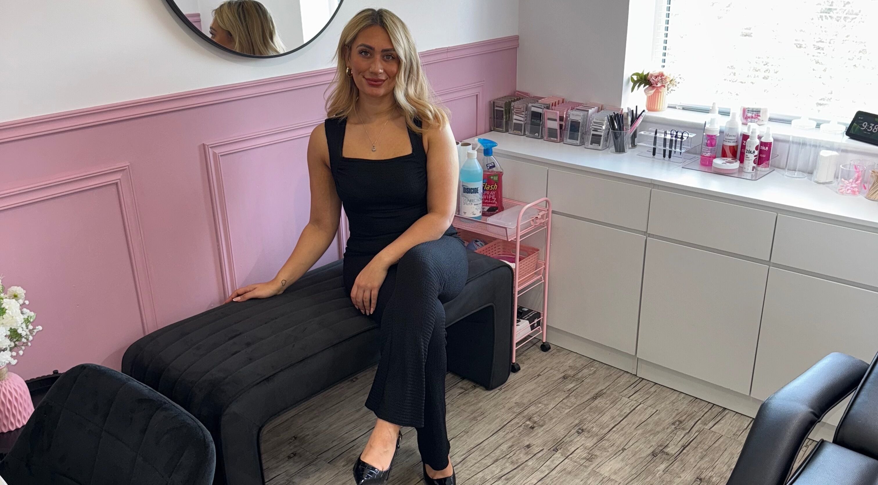 A stylist at LMA Beauty21 in Gloucester, England, GB in a modern, pink-accented salon space.