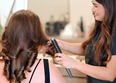 Stylist curling hair at Lish Beauty Bar, Dubai, Dubai, AE, showcasing expert hair styling services.