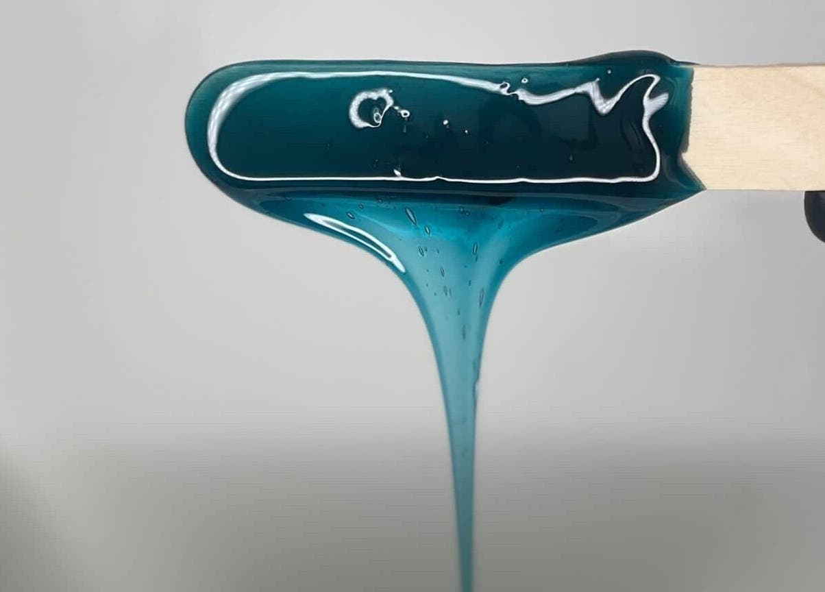 Close-up of teal wax on spatula at Bare Beauty in Edinburgh, Scotland, GB, showcasing premium waxing service.