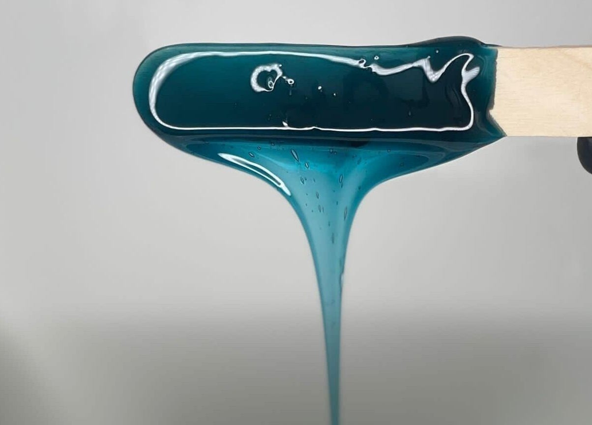 Close-up of teal wax on spatula at Bare Beauty in Edinburgh, Scotland, GB, showcasing premium waxing service.