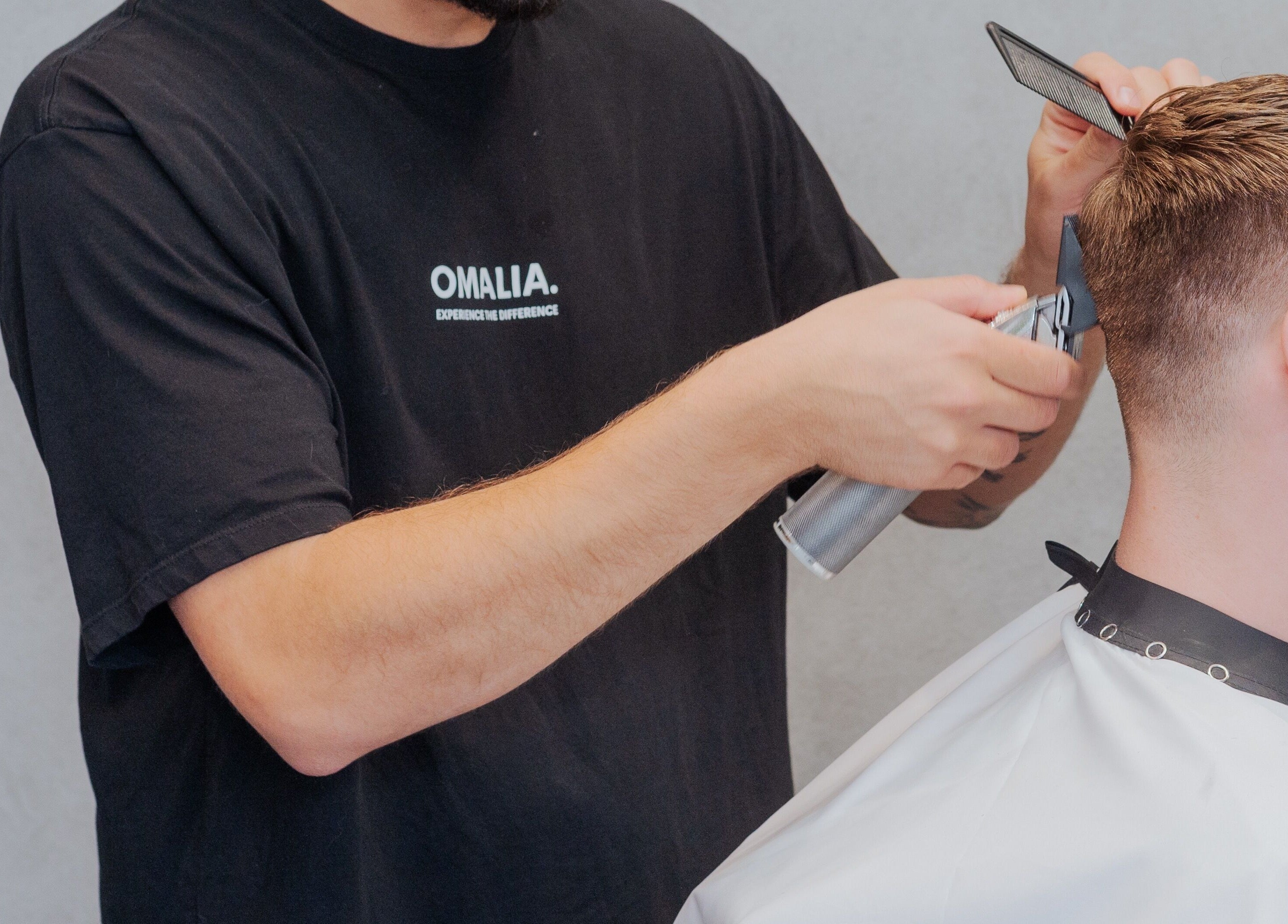 Hairdresser at OMALIA. ST LEONARDS giving a stylish haircut. Located in St Leonards, New South Wales, AU.