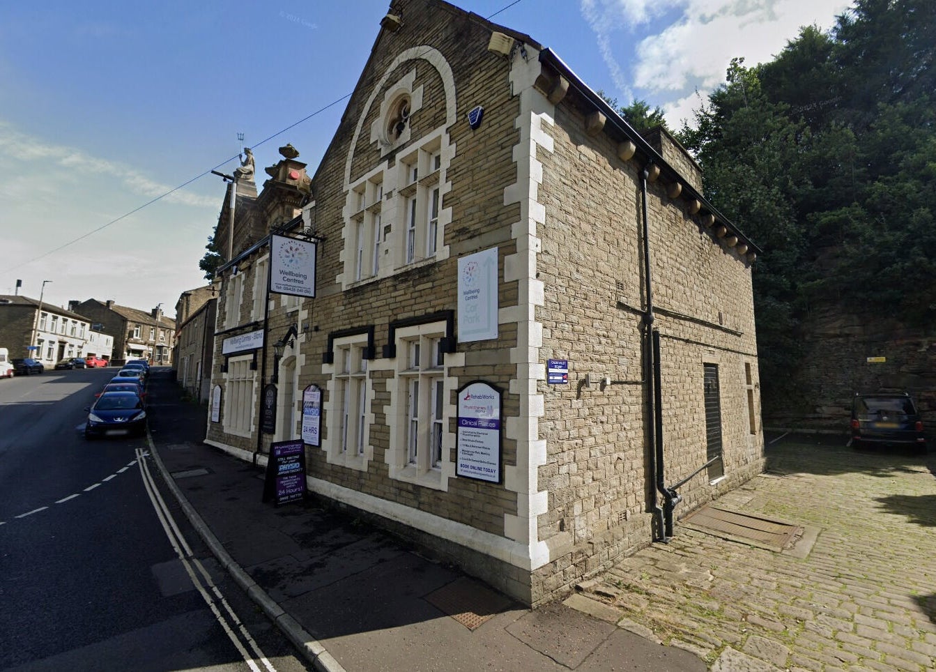 Stone building of Lioness' Den in Elland, England, GB, showcasing traditional architecture and wellness signs.