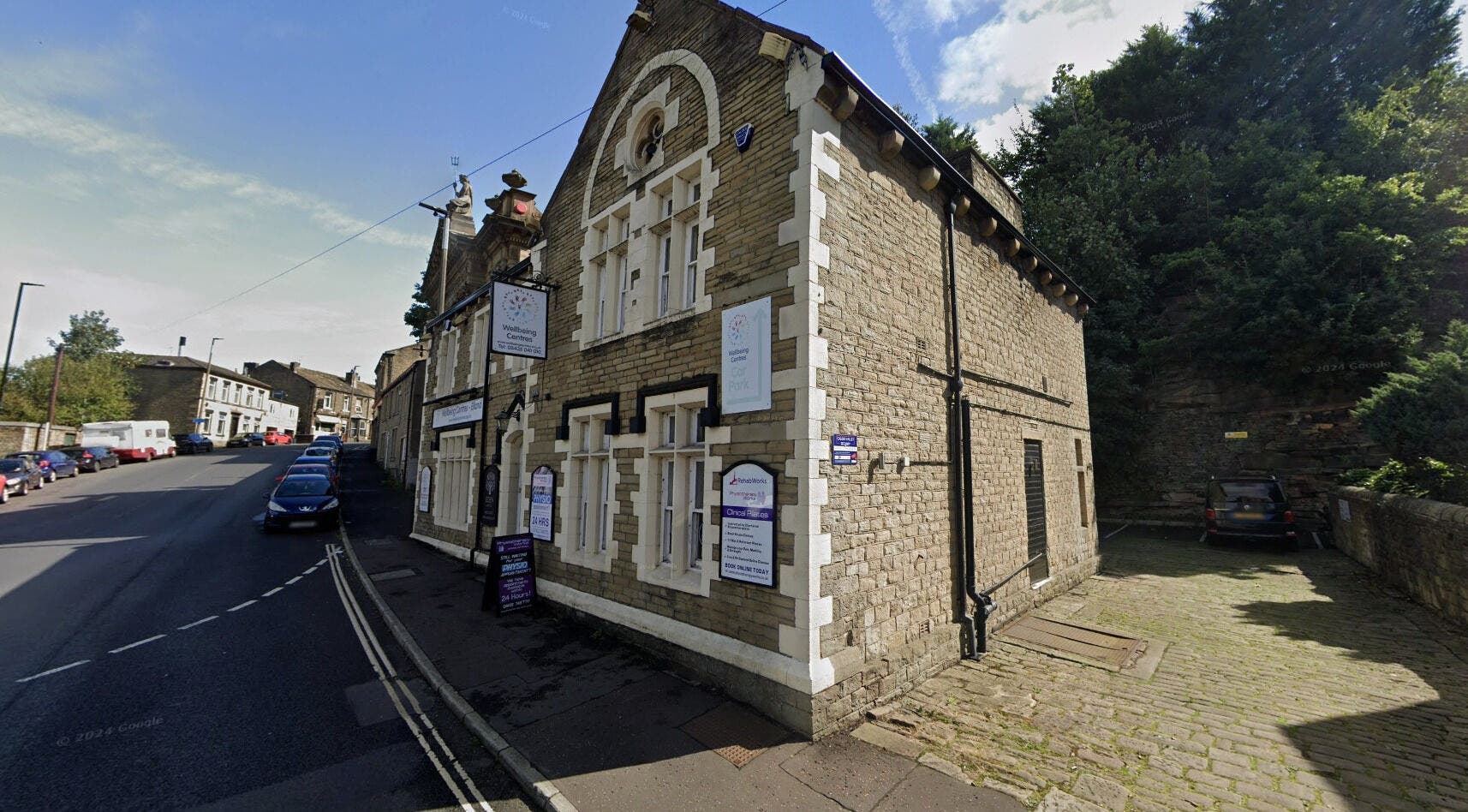 Stone building of Lioness' Den in Elland, England, GB, showcasing traditional architecture and wellness signs.