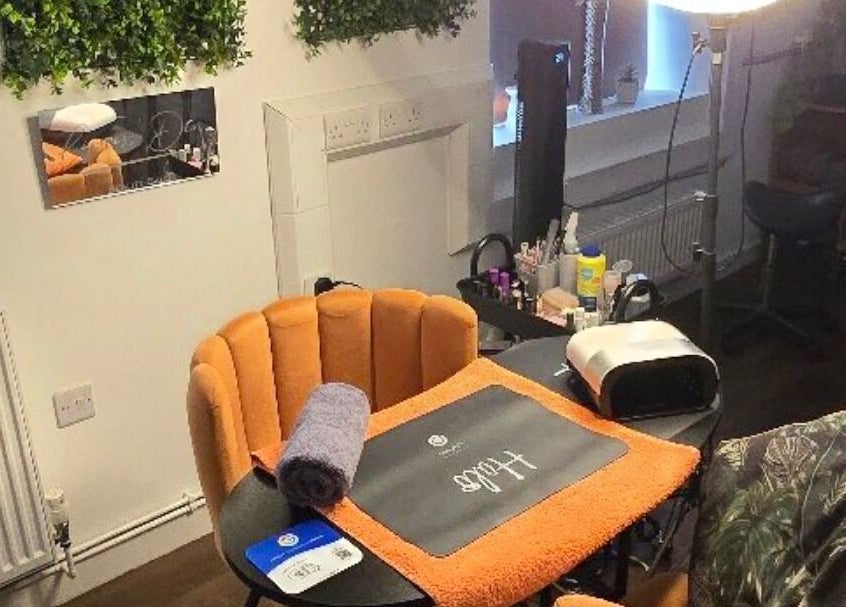 Bright and cozy beauty station at Lioness' Den, Elland, England, GB, featuring orange seating and wellness tools.