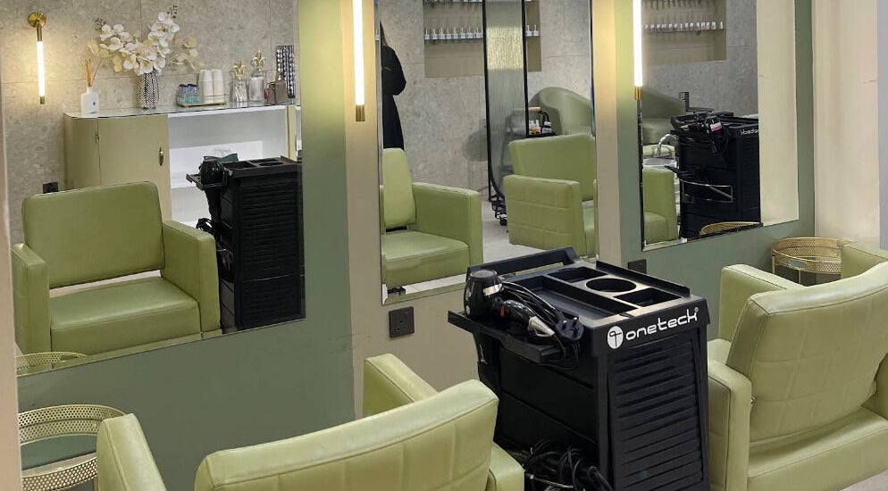 مقاعد خضراء ومرايا في صالون يوني كيور للسيدات بالخبر، المنطقة الشرقية، السعودية.