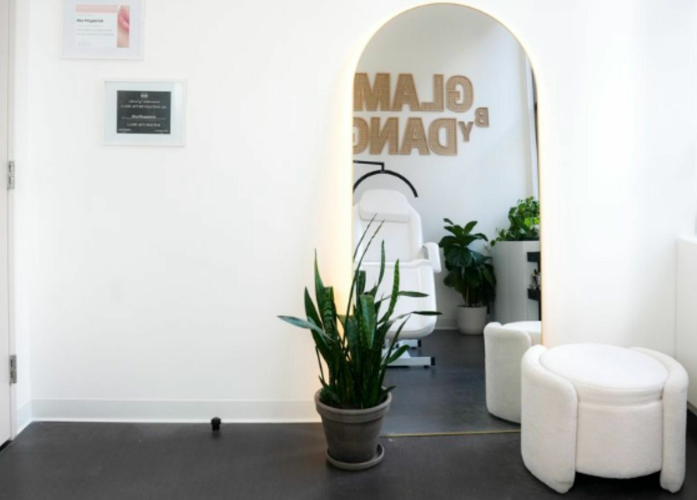 Serene interior at Glam by Dang, New York, New York, US, featuring a chic mirror, stylish seating, and verdant plants.