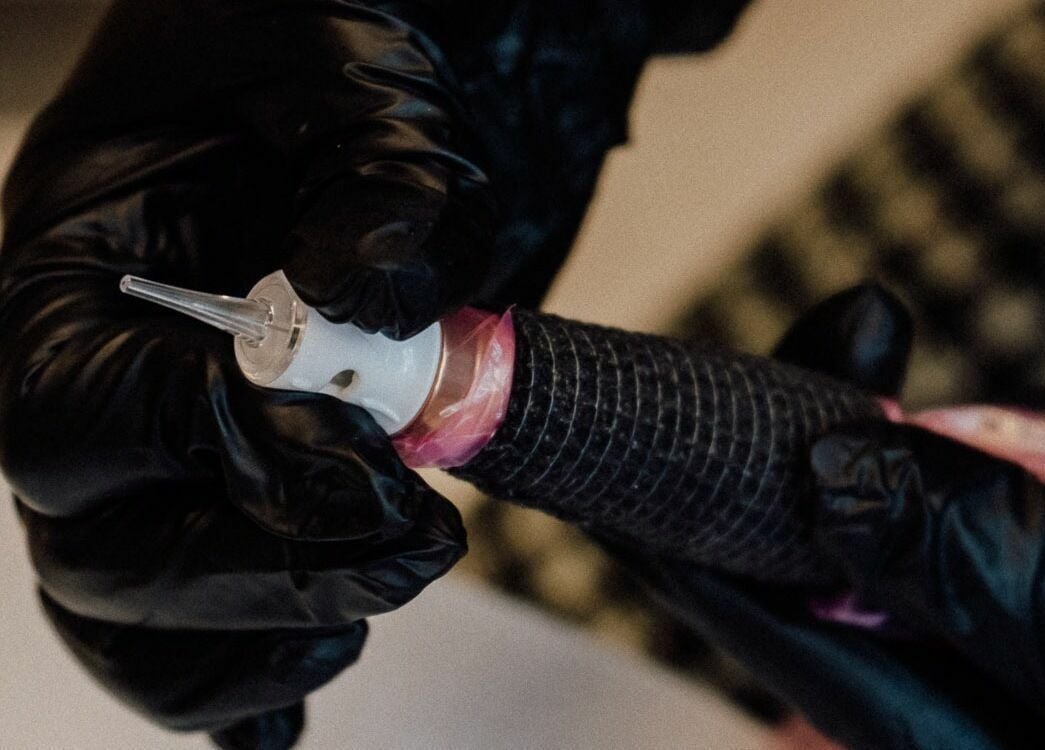 Tattoo machine at Glam by Dang in New York, New York, US, highlighting precision and artistry.