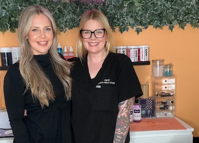 Team members at Peach Wax Studio, Kelso, Scotland smiling in front of treatment area.