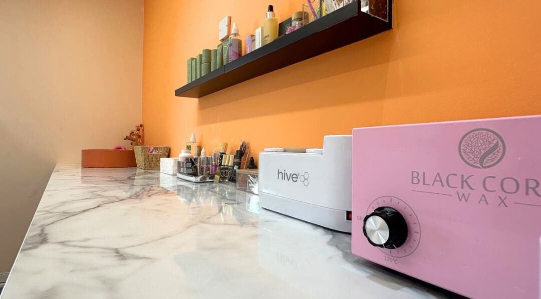Waxing supplies and equipment at Peach Wax Studio, Kelso, Scotland, GB with vibrant orange wall.