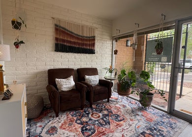 Relaxing lounge with plush chairs and plants at Fusion Therapeutic Bodywork, Tucson, Arizona, US.