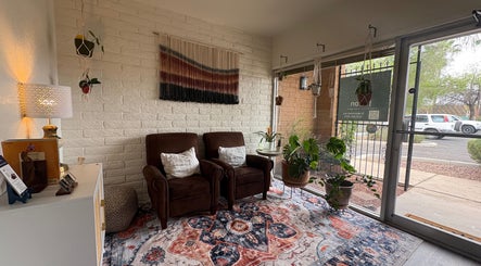 Relaxing lounge with plush chairs and plants at Fusion Therapeutic Bodywork, Tucson, Arizona, US.