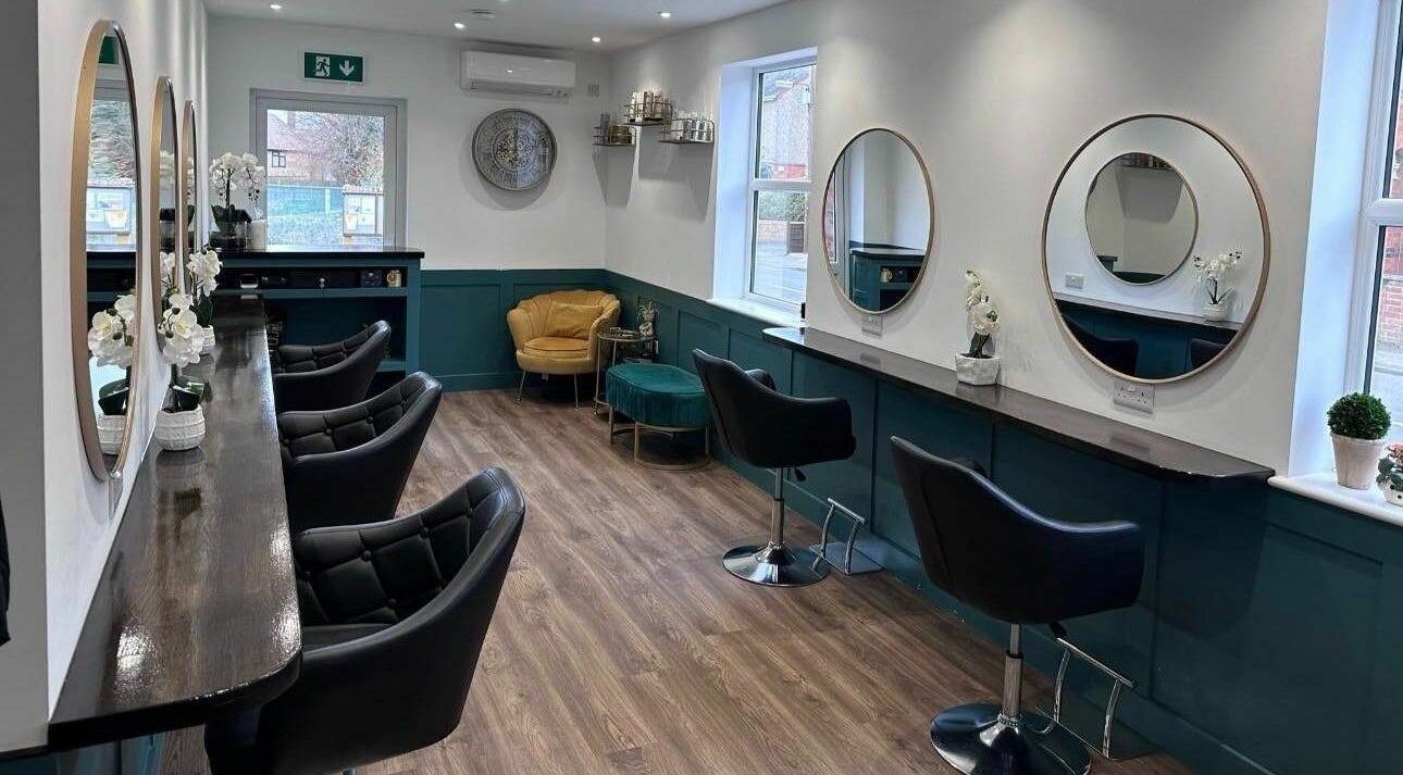 Elegant interior of Jewells Hair in Cogenhoe, England, GB featuring mirrors and stylish chairs.