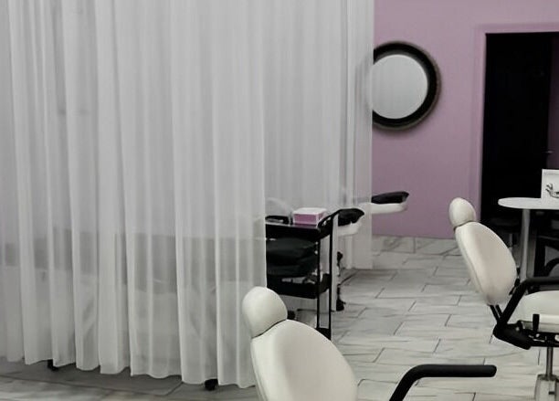 Interior of Bella Spa in Omaha, Nebraska, with modern chairs and elegant white drapes for privacy.