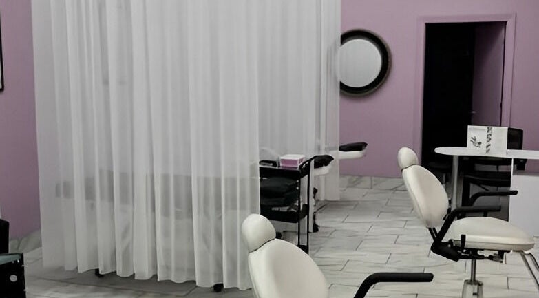 Interior of Bella Spa in Omaha, Nebraska, with modern chairs and elegant white drapes for privacy.