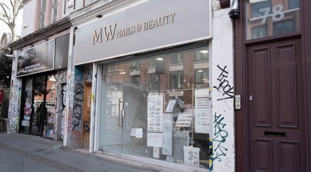 Exterior of MW Nails and Beauty Salon, London, England, GB, showcasing chic glass frontage on a city street.
