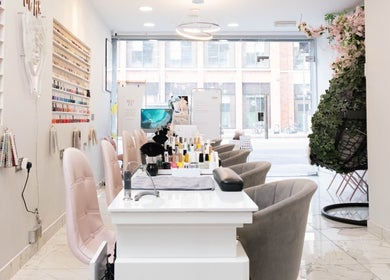 Elegant interior of MW Nails and Beauty Salon in London, England, GB with nail polish displays and plush chairs.