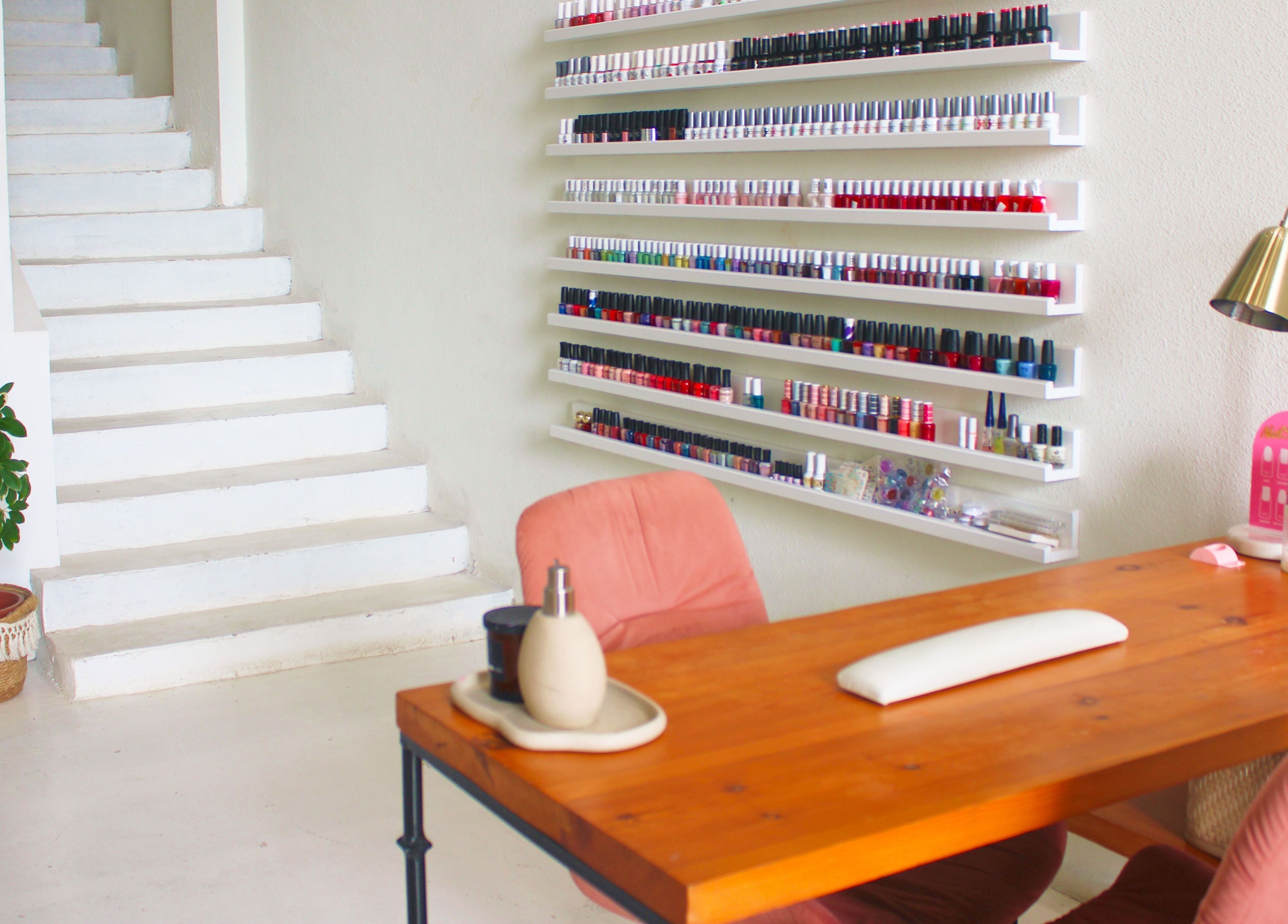 Elegant nail salon interior at Nash ناش, Riyadh, Riyadh Province, SA with polish display and cozy seating.