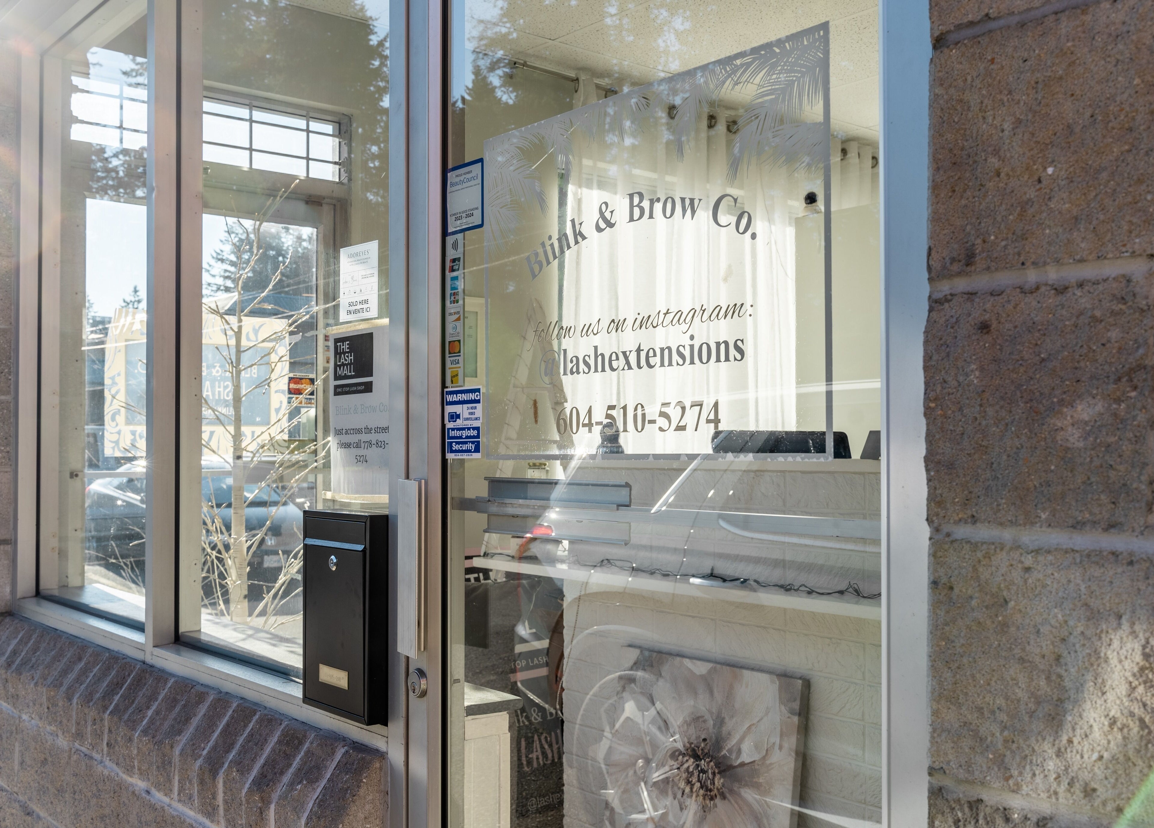 Front entrance of Blink & Brow Co. BROOKSWOOD in Langley Township, British Columbia, CA, showcasing their glass door.