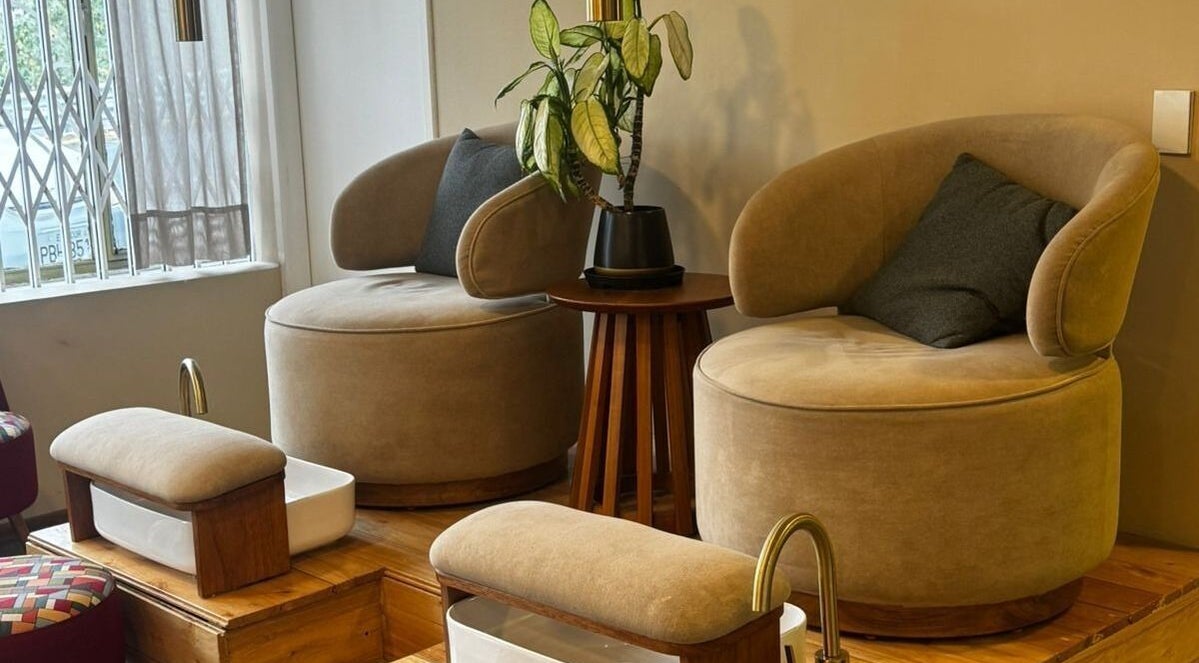 Espacio de descanso elegante en Naturale, Quito, Pichincha, EC, con sillas cómodas y detalles de planta decorativa.