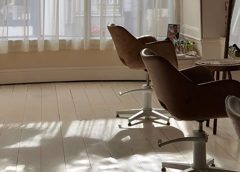 Bright salon chairs by a sunlit window at Morgelyn Studio, Penzance, England, GB, showcasing a tranquil space.