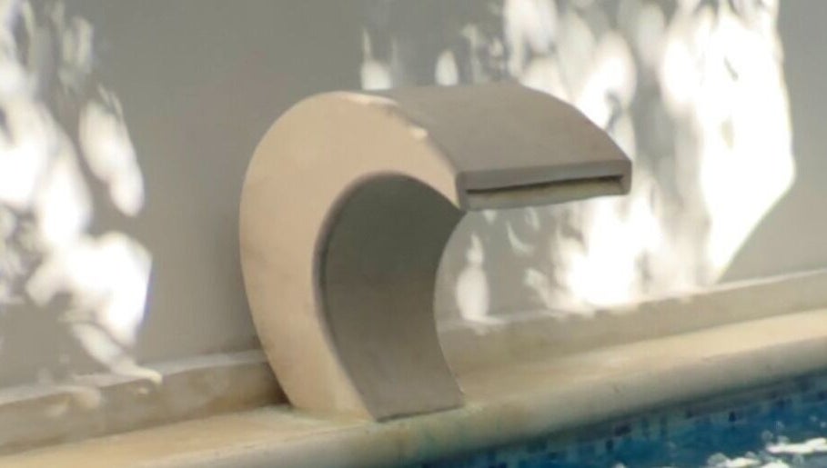 Relajante cascada de agua en Flora Spa, Tulum, Quintana Roo, MX, creando un ambiente de serenidad.