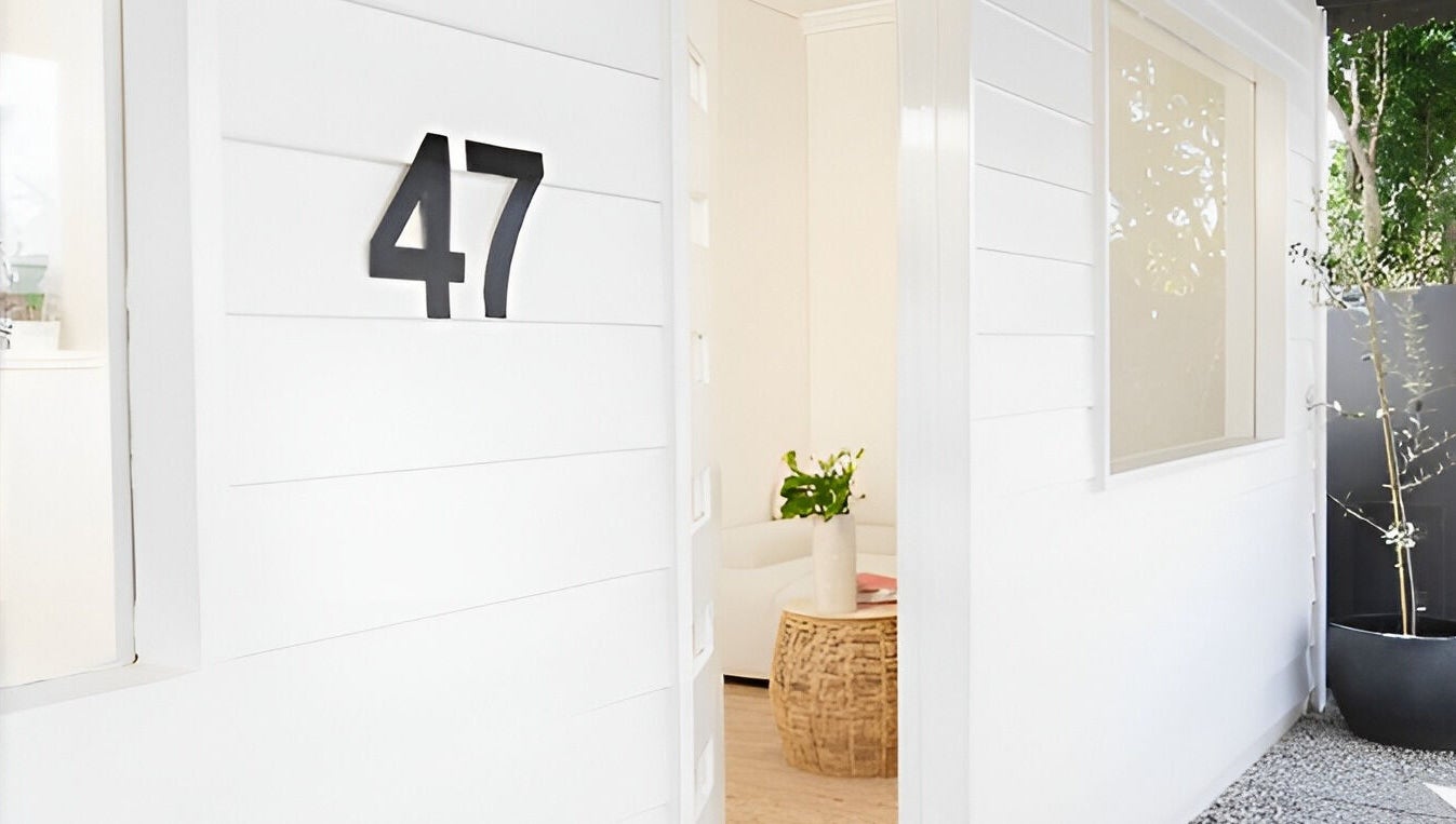 White-walled entrance of The Mane Stylist at Red Hill, Queensland, AU, showcasing elegance and modern design.