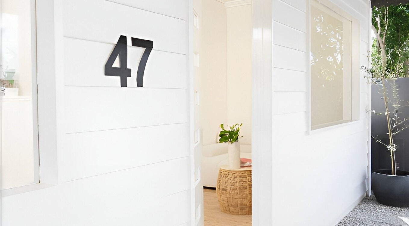 White-walled entrance of The Mane Stylist at Red Hill, Queensland, AU, showcasing elegance and modern design.