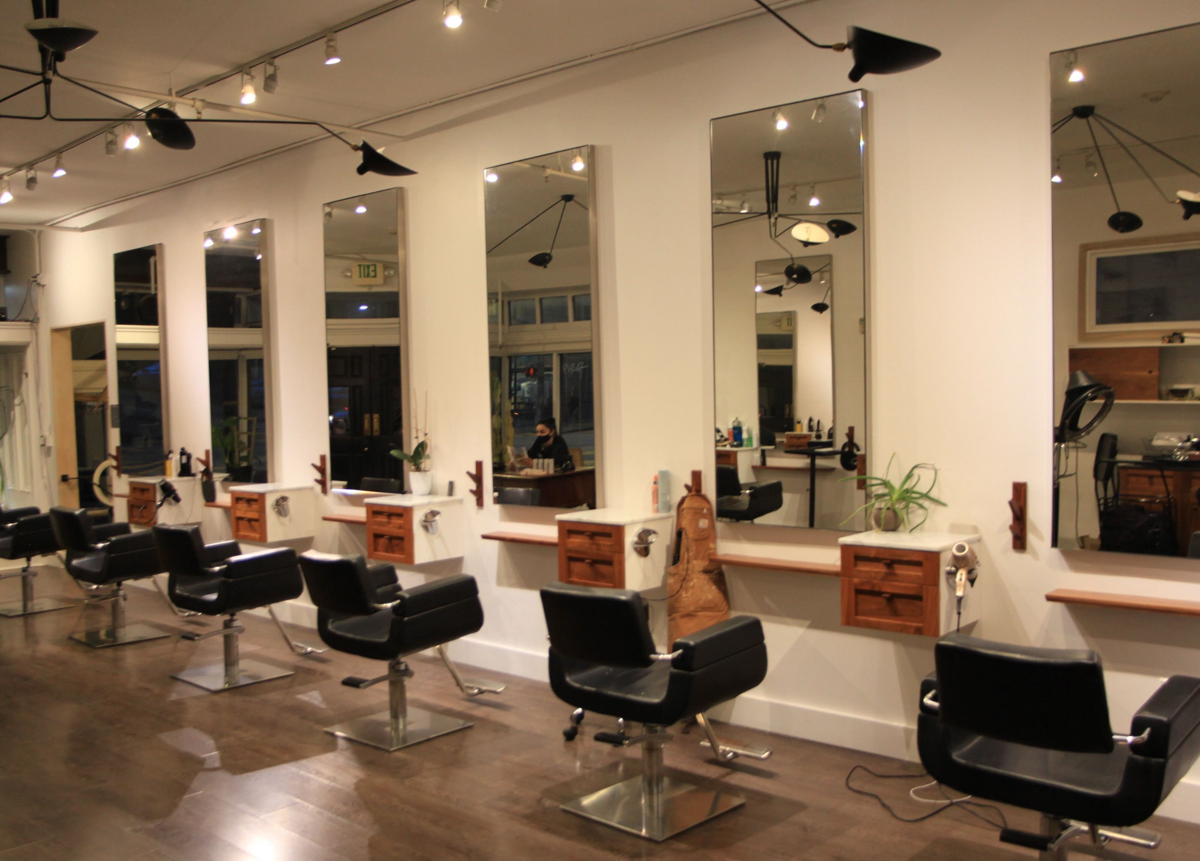 Modern salon interior at David James San Francisco, California, US with sleek styling stations and mirrors.