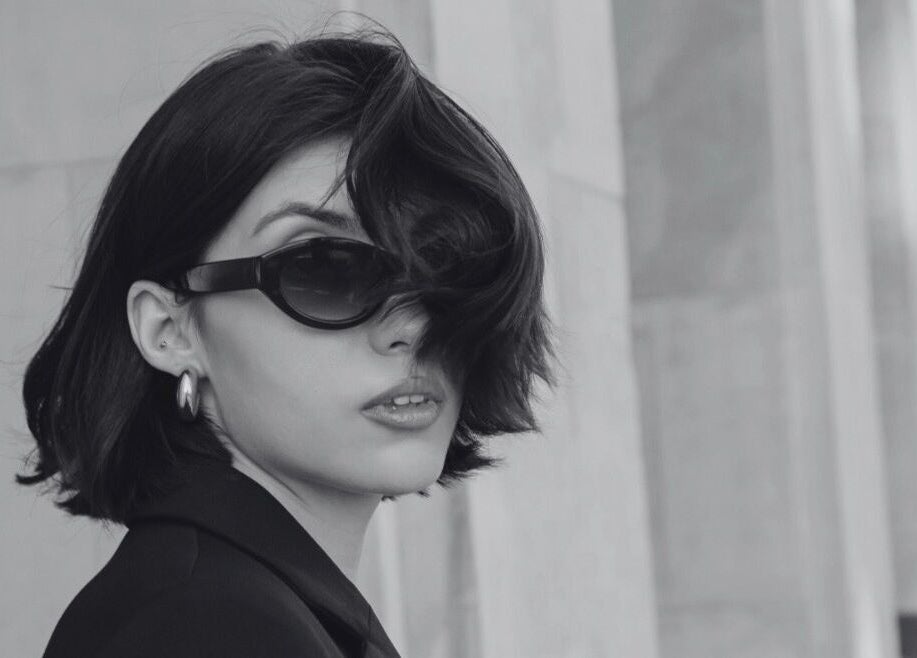 Elegant woman in sunglasses outside David James San Francisco, CA, showcasing timeless style.