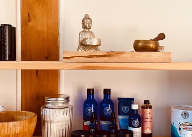 Shelf at Balanced & Blissed - The Retreat, Whitfield, England, GB showcasing wellness products and a Buddha statue.