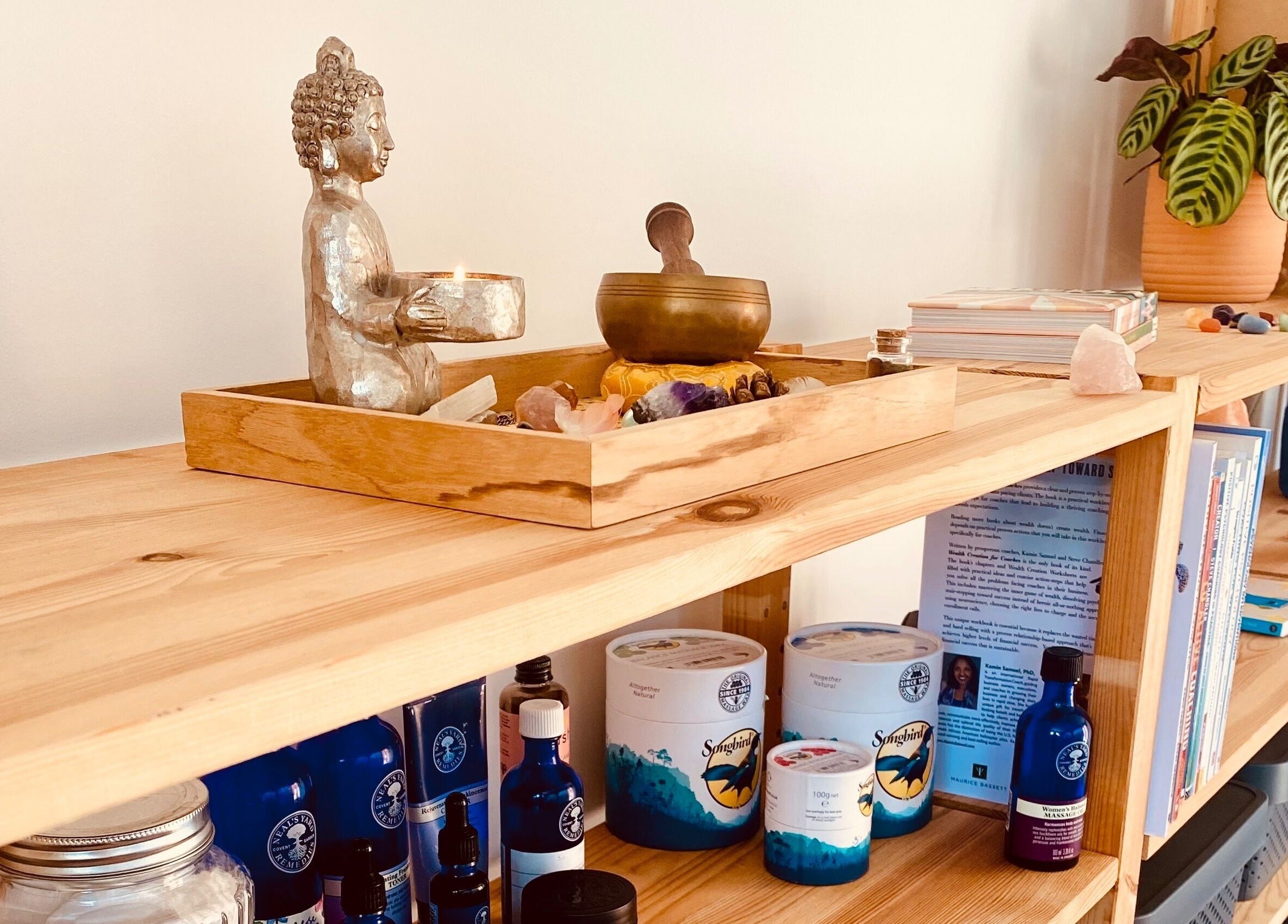 Decorative shelf at Balanced & Blissed - The Retreat, Whitfield, England with wellness items and a Buddha statue.