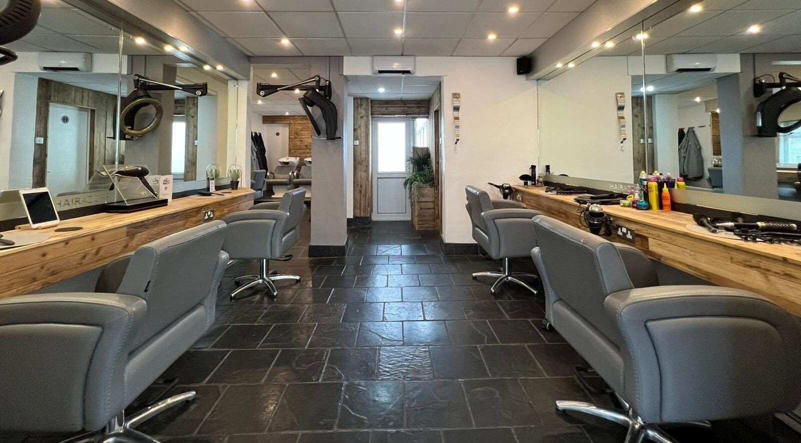 Modern interior of Hairazors Hairdressing Ltd salon, Paignton, England with sleek chairs and stylish mirrors.