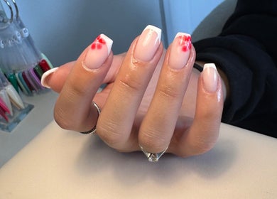 Stylish nail art design at Aaliyahbrookesbeauty in Telford, England, GB, featuring French tips with red accents.