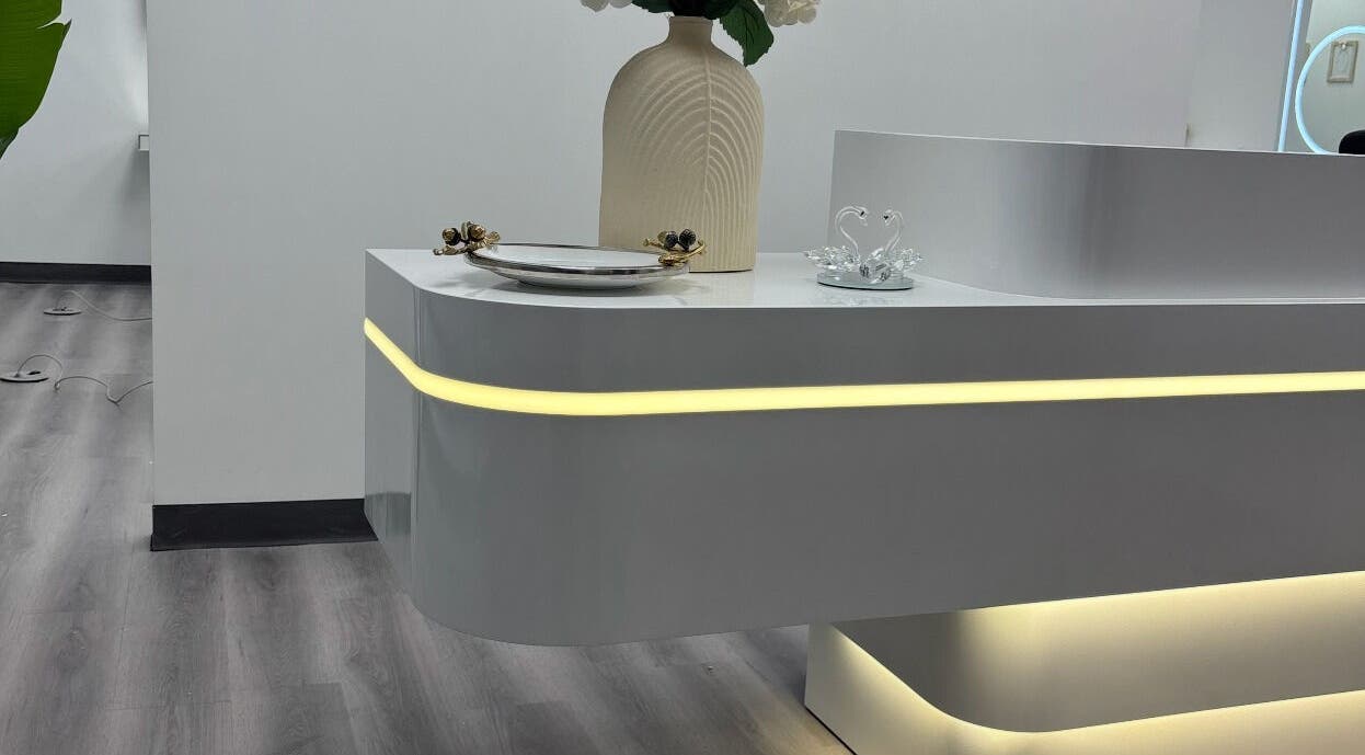 Sleek reception desk at Urban Brows West in Edmonton, Alberta, CA, offering a modern and inviting ambiance.