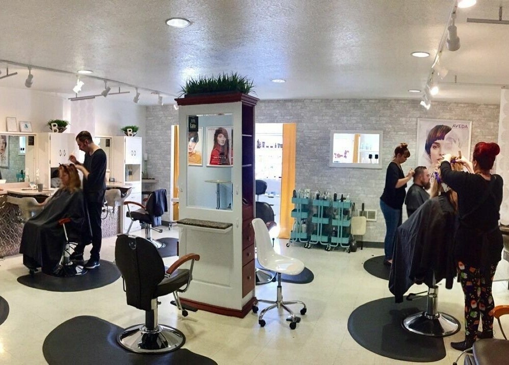 Inside Bombshells and Blokes Salon in Boise, Idaho. Stylists working with clients in a modern, bright setting.
