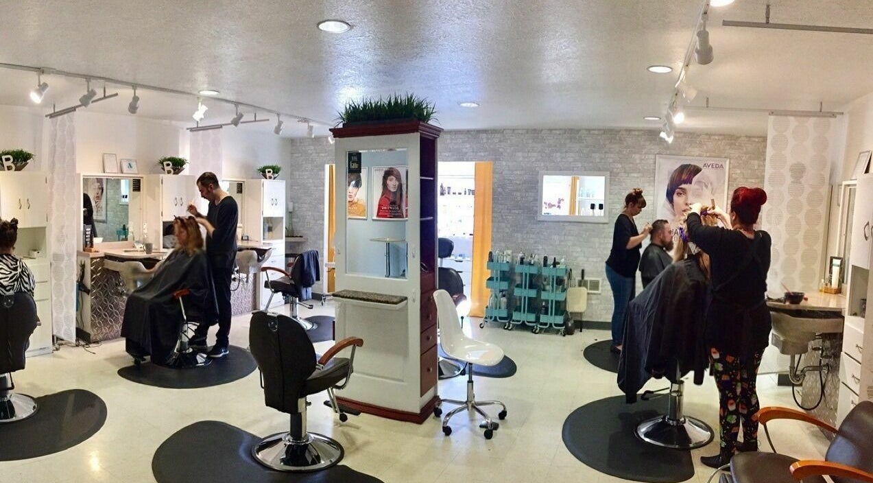 Inside Bombshells and Blokes Salon in Boise, Idaho. Stylists working with clients in a modern, bright setting.