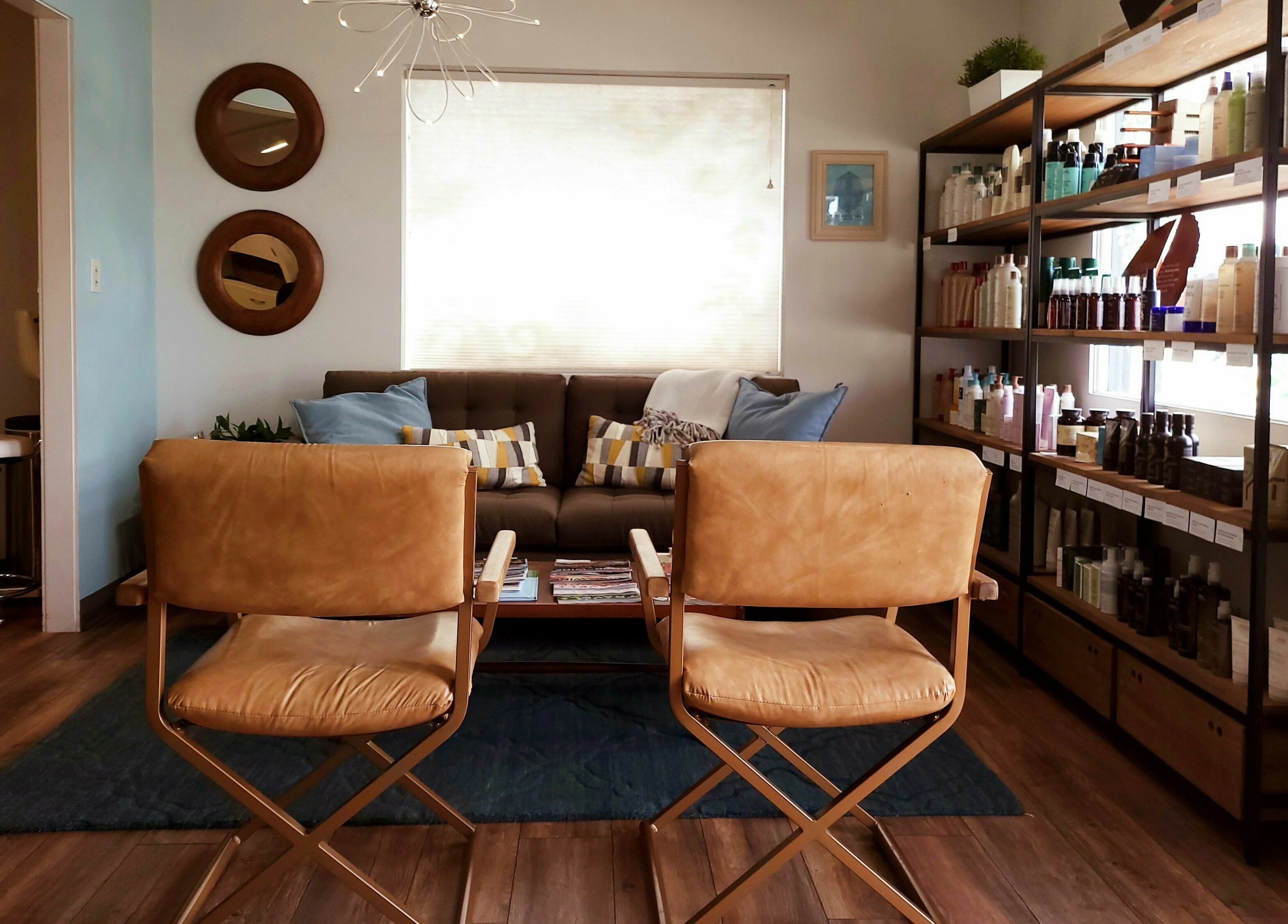 Modern salon interior at Bombshells and Blokes Salon, Boise, Idaho, US, featuring stylish seating and product shelves.