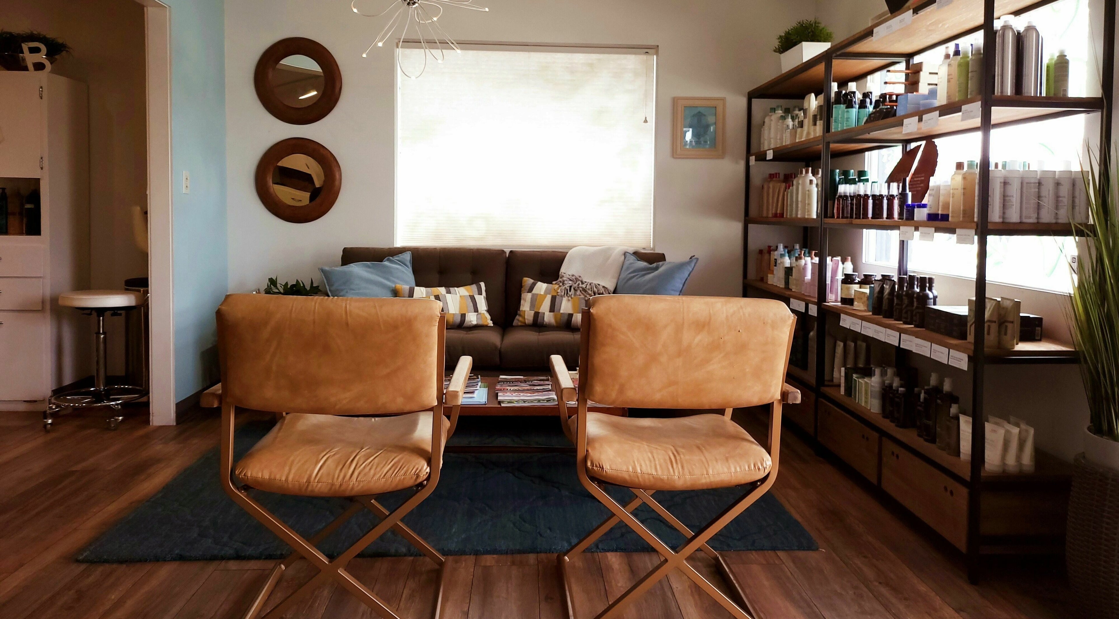 Modern salon interior at Bombshells and Blokes Salon, Boise, Idaho, US, featuring stylish seating and product shelves.