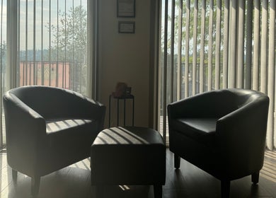 Cozy seating area at Skinfluential LLC, West Linn, Oregon, US, with two armchairs by a window.
