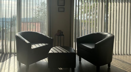 Cozy seating area at Skinfluential LLC, West Linn, Oregon, US, with two armchairs by a window.