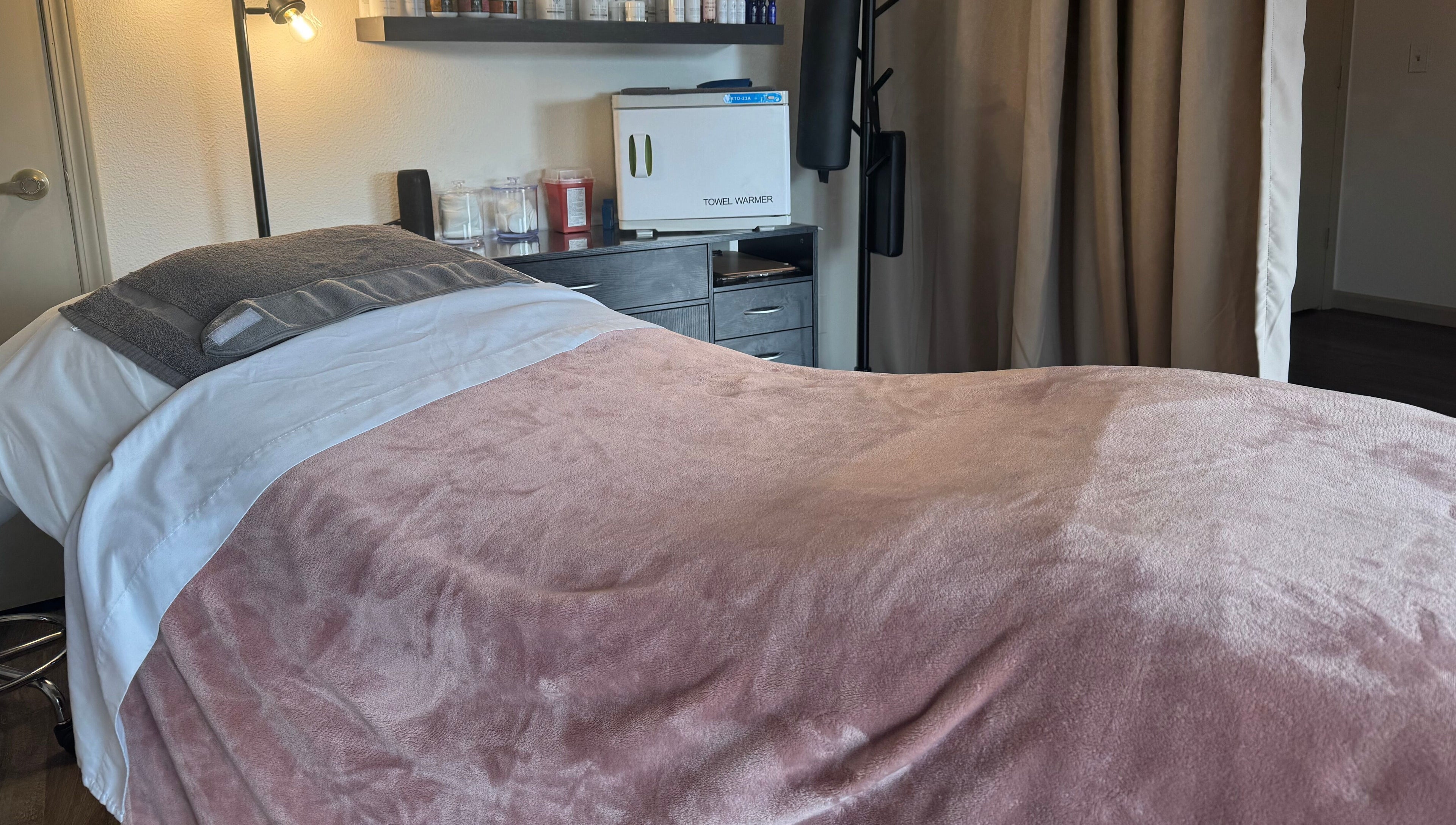 Cozy treatment room at Skinfluential LLC, West Linn, Oregon, US, with plush pink blanket and modern decor.