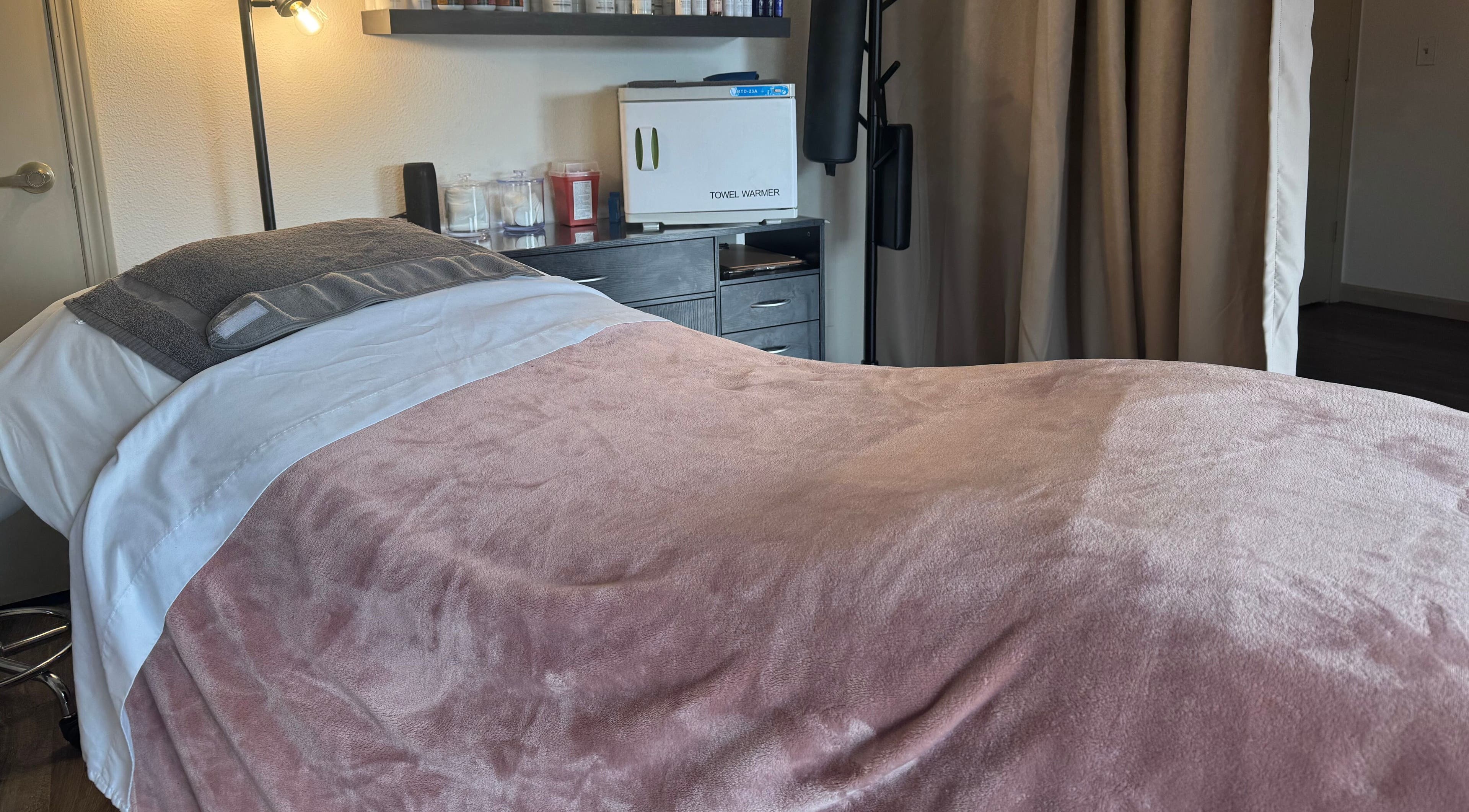 Cozy treatment room at Skinfluential LLC, West Linn, Oregon, US, with plush pink blanket and modern decor.