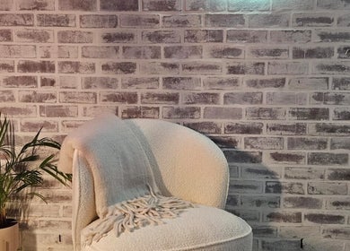 A cozy chair with a soft blanket near a potted plant at Lyndal's - Lash Brow & Beauty in Cape Town, Western Cape, ZA.