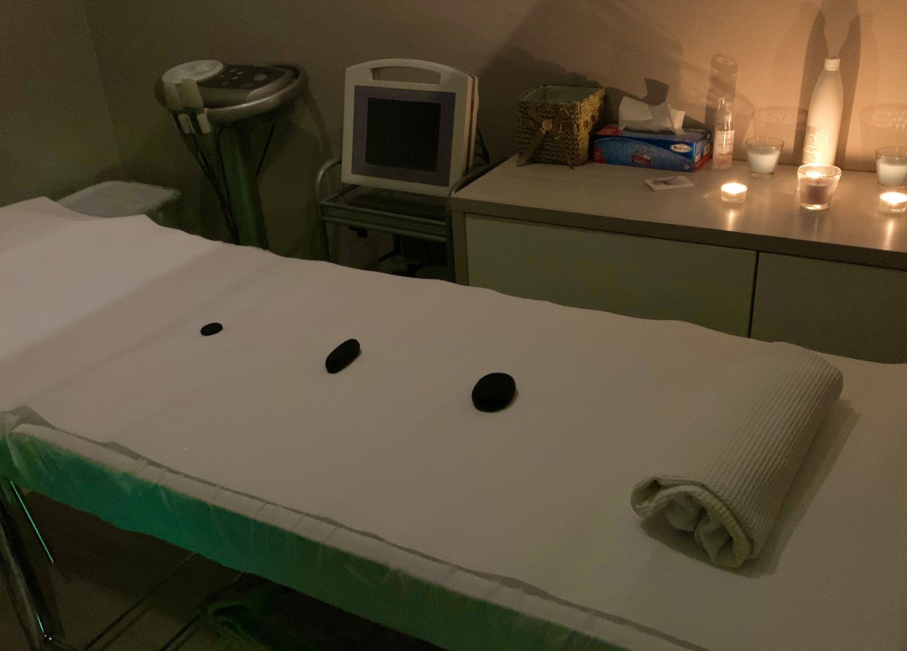 Camera di massaggio presso Crystal Estetica - Pomezia (RM), Pomezia, Lazio, IT, con candele accese e pietre calde.