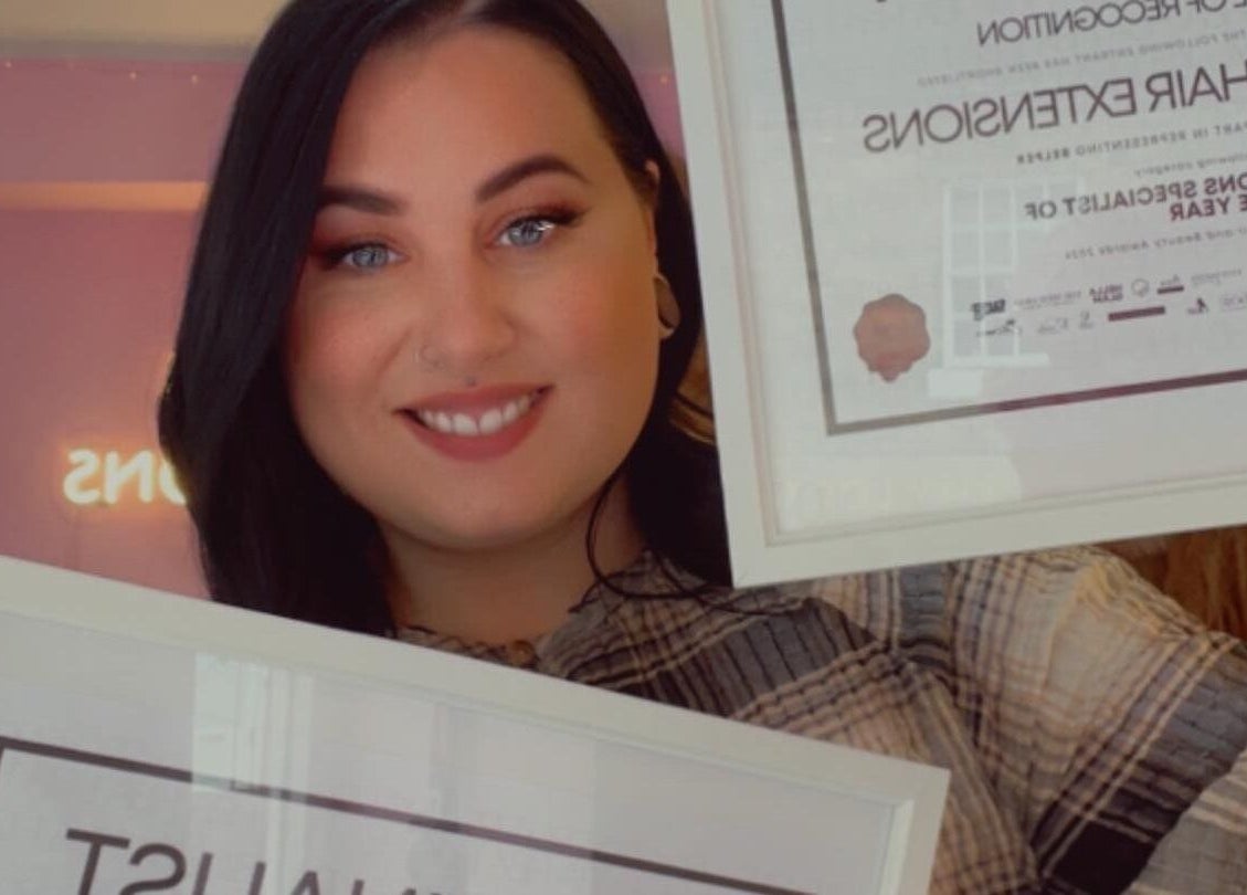 Person proudly holds awards at Loxy Locks Hair Extensions in Belper, England, GB, showcasing excellence.