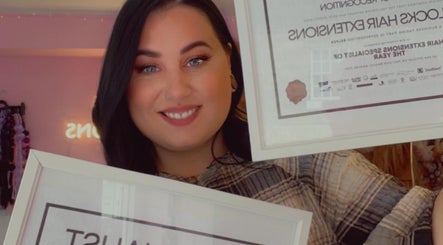 Person proudly holds awards at Loxy Locks Hair Extensions in Belper, England, GB, showcasing excellence.