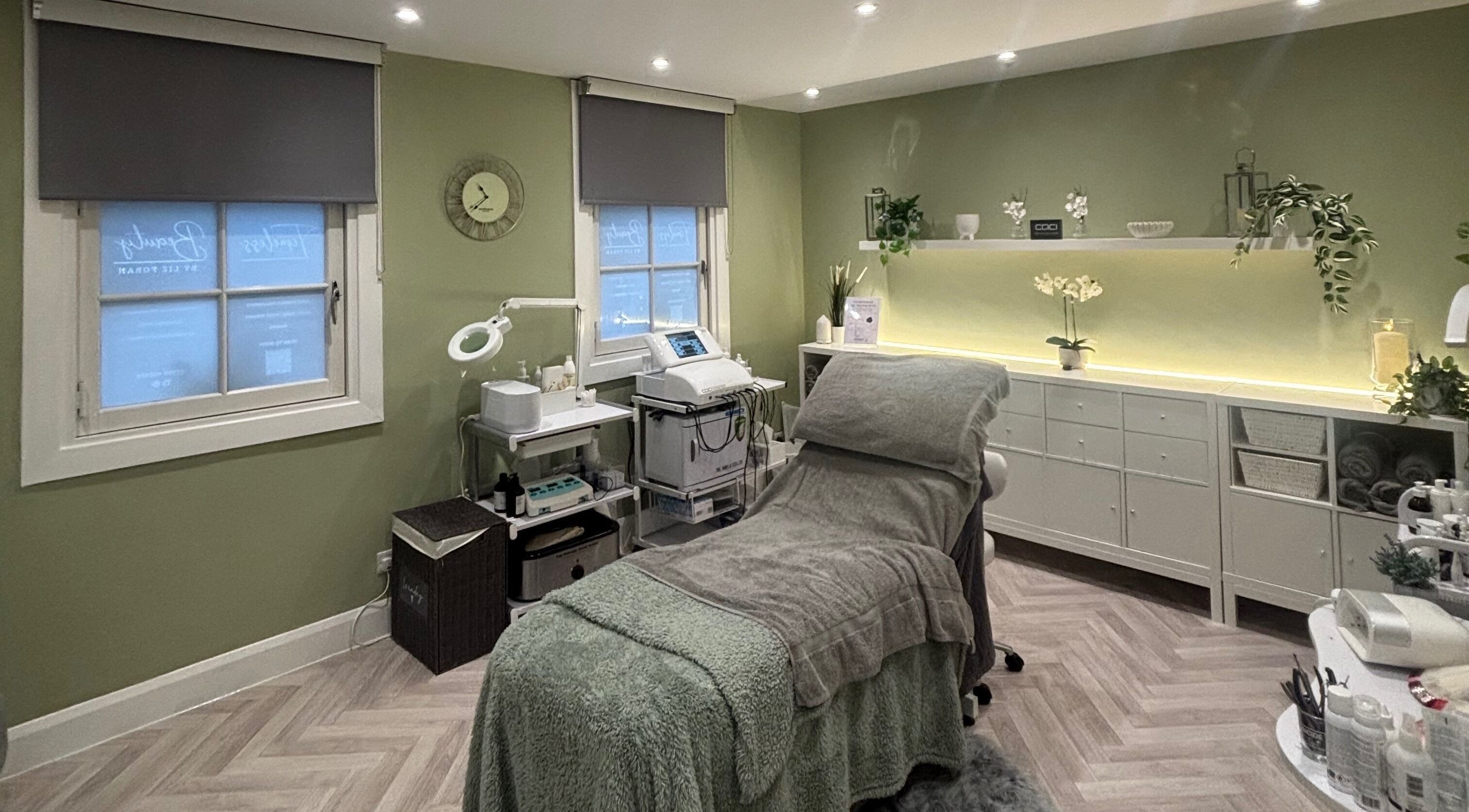 Relaxing treatment room at Timeless Beauty by Liz Foran in Paisley, Scotland, GB with a calming green palette.